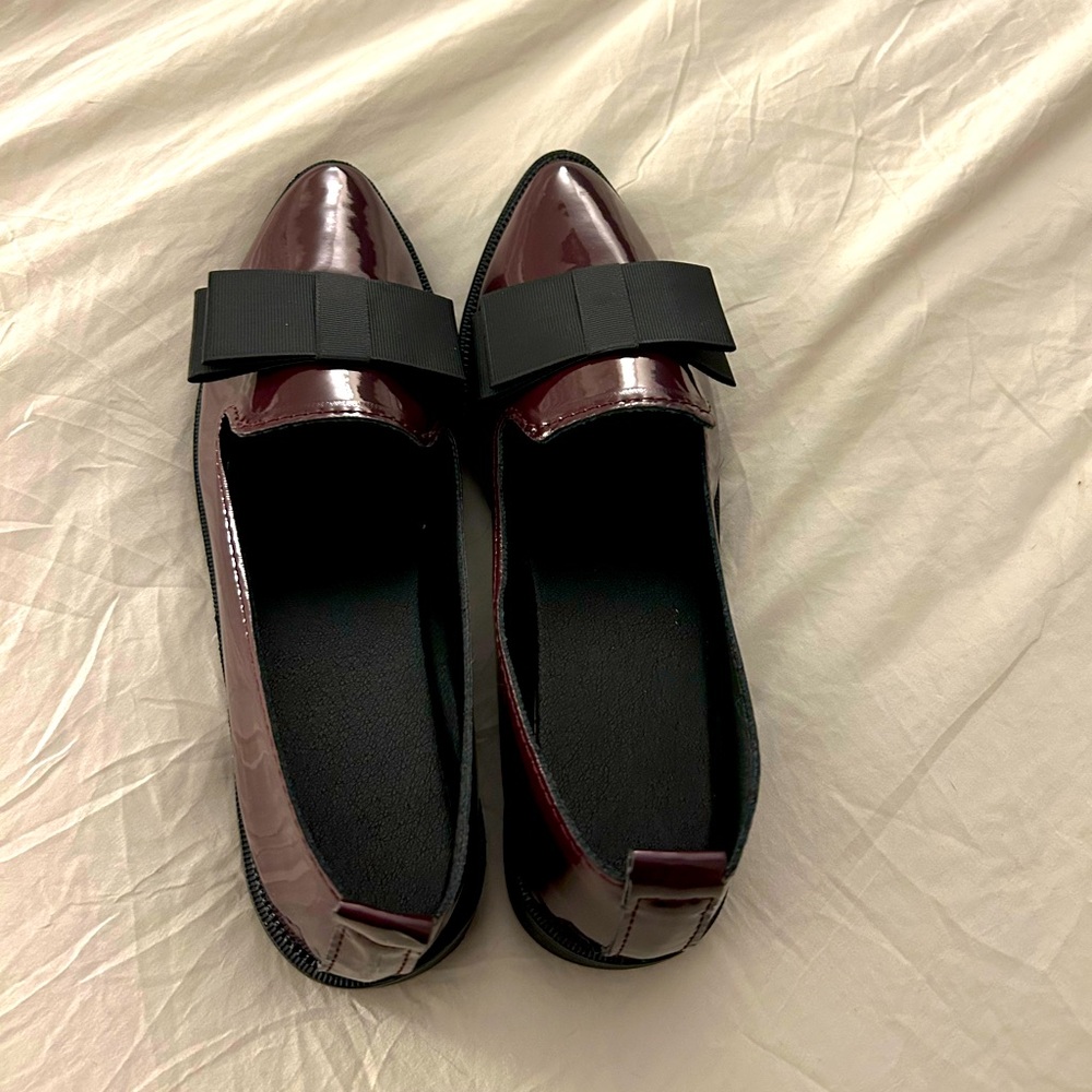 Women’s burgundy and black loafers with bow tie.
